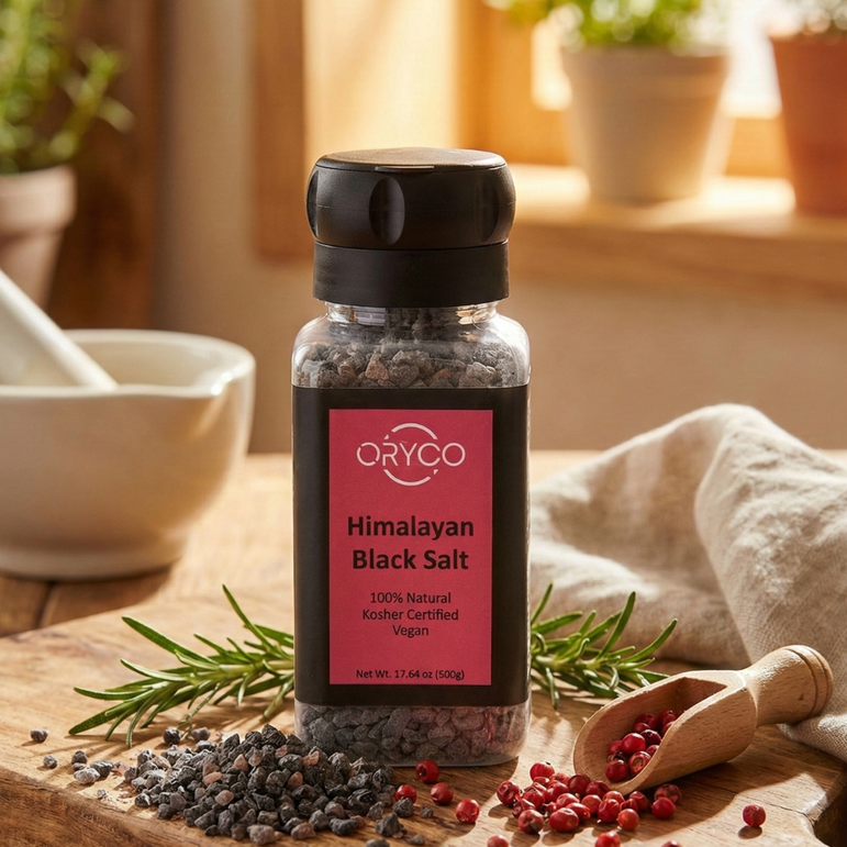 Black Salt bottle on a wooden cutting board with herbs and a mortar and pestle