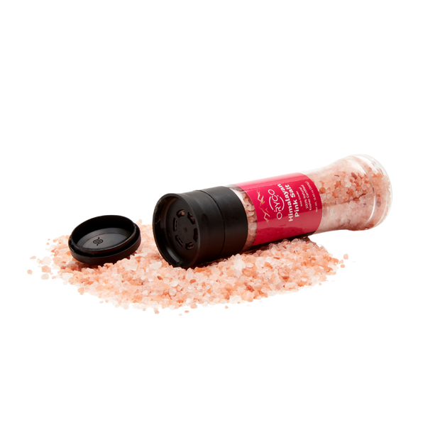 Himalayan pink salt shaker with pink salt on a white background